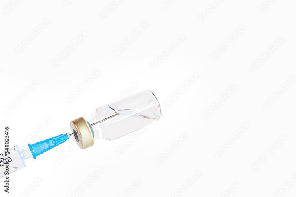 syringe needle injecting into vaccine bottle
