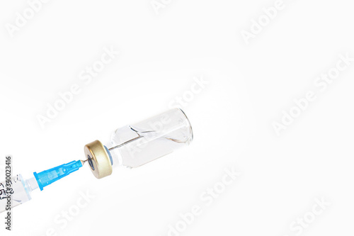 syringe needle injecting into vaccine bottle