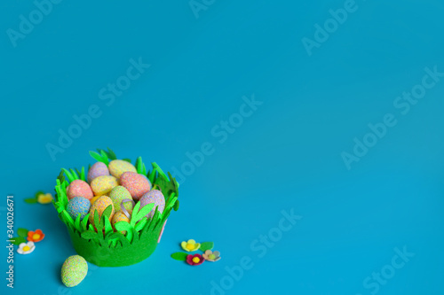 Easter eggs in a handmade basket on blue background