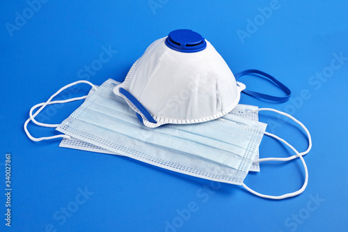 Respirator FFP2 and surgical masks on blue background