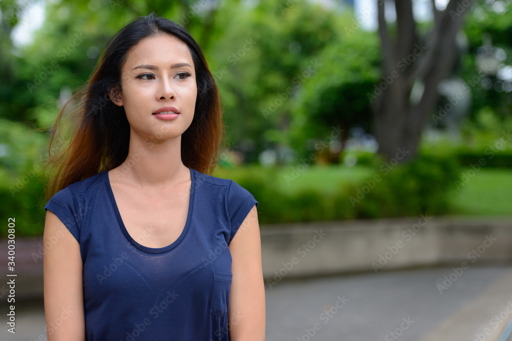 Young beautiful Asian businesswoman thinking in the park Young beautiful Asian businesswoman thinking in the park