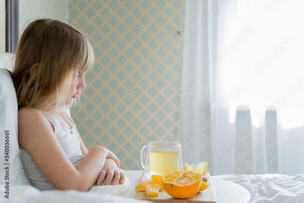 Little sick girl in bed with cup of antipyretic drugs for colds,flu.Tea with citrus vitamin C,ginger root,lemon,orange.Wooden tray. Home self-treatment.Medical quarantine covid-19 coronavirus therapy Little sick girl in bed with cup of antipyretic drugs for colds,flu.Tea with citrus vitamin C,ginger root,lemon,orange.Wooden tray. Home self-treatment.Medical quarantine covid-19 coronavirus therapy