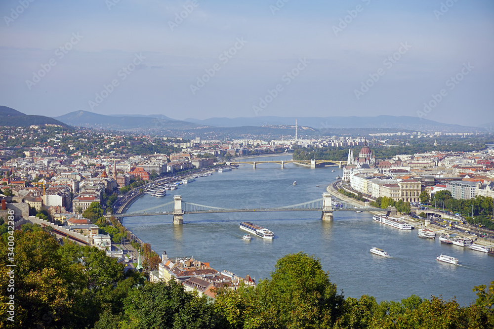 Panoramic summer view of Buda and Pest in Budapest, in the frame the majestic Danube River, Secheni Chain Bridge, the building of the Hungarian Parliament on the banks of the Danube River