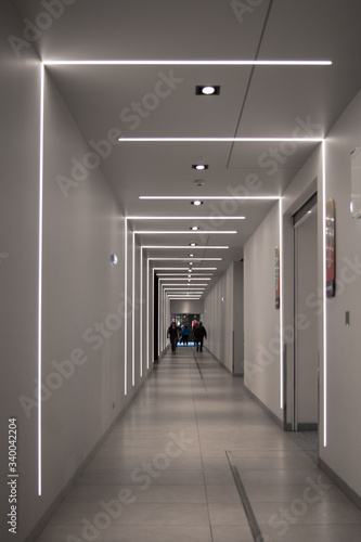 A long, long passage in the subway with an interesting geometric highlight, forming a visual rhythm. People are walking along it