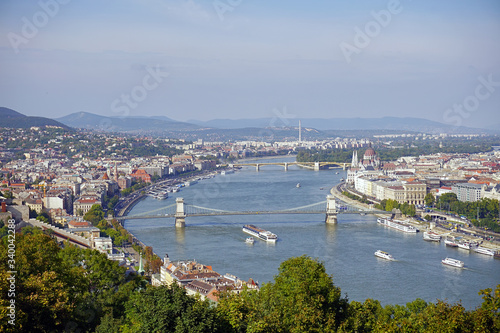 Panoramic summer view of Buda and Pest in Budapest, in the frame the majestic Danube River, Secheni Chain Bridge, the building of the Hungarian Parliament on the banks of the Danube River photo