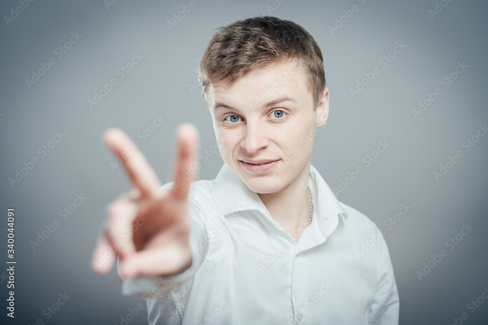 young man in showing victory or peace sign young man in showing victory or peace sign