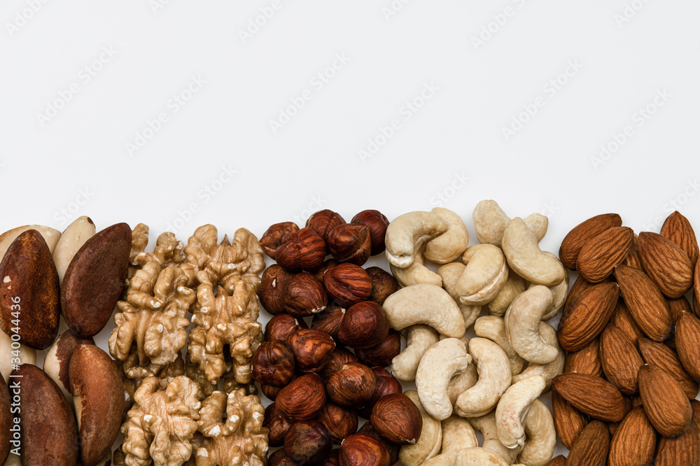 Raw nuts isolated on white background with empty copy space, almonds, cashews, hazelnuts, Brazil nuts and walnuts Raw nuts isolated on white background with empty copy space, almonds, cashews, hazelnuts, Brazil nuts and walnuts