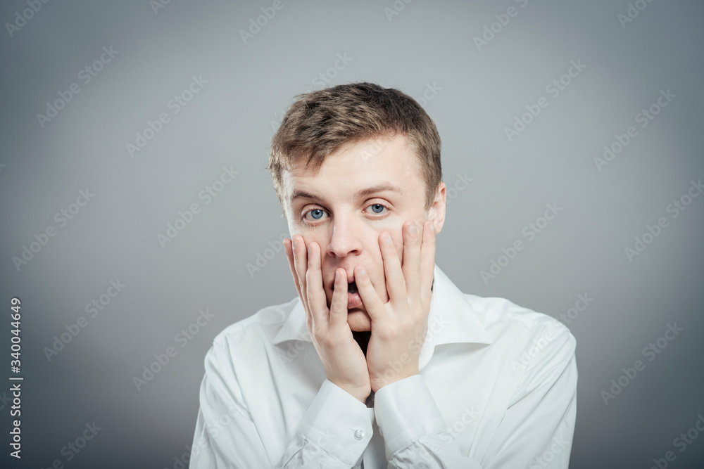 a young man upset with hands on face a young man upset with hands on face