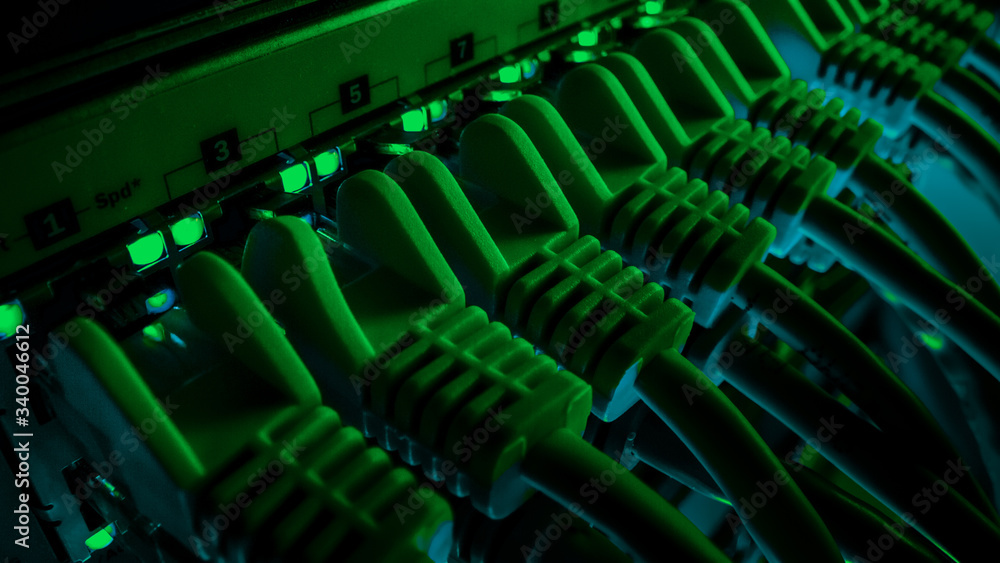 Macro Shot: Ethernet Data Cables Connected to Router Ports with Blinking Lights. Information Technology with RJ45 Internet Connectors Plugged into Modem LAN Switches. Background Green Lighting Macro Shot: Ethernet Data Cables Connected to Router Ports with Blinking Lights. Information Technology with RJ45 Internet Connectors Plugged into Modem LAN Switches. Background Green Lighting