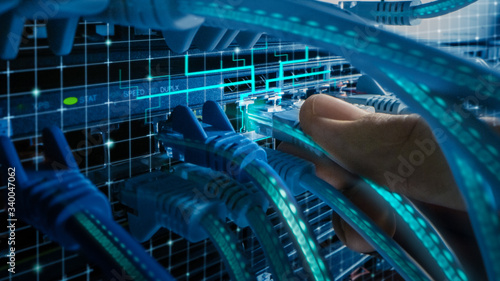 Macro Shot with Augmented Reality:  IT Administrator Plugs in RJ45 Internet Connector into LAN Router Switch. Cables with Virtual Graphichs Showing Data Transfer.