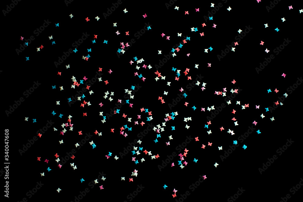 multicolored confectionery sprinkle in the form of butterflies on a black background