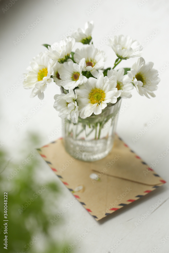 chamomile flowers in a glass on the windowsill
