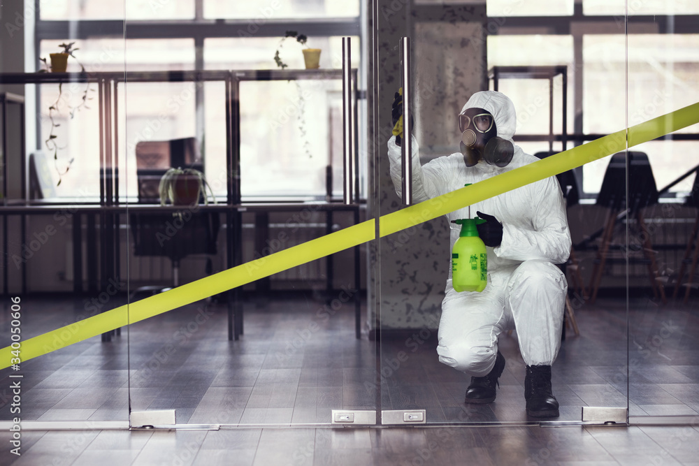Obraz premium Cleaning and Disinfection at town complex amid the coronavirus epidemic. Professional teams for disinfection efforts. Infection prevention and control of epidemic. Protective suit and mask