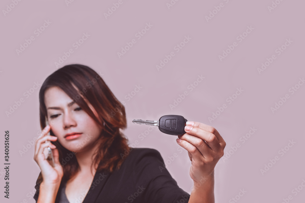 Asian woman regret when holding her car key on background. Asian woman regret when holding her car key on background.