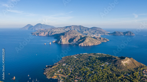Beautiful panoramic aerial view photo from flying drone on Vulcano Island to Lipari and Salina Island of the Aelian Islands, Italy on a summer with blue sky (series)