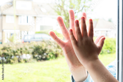 Father and son`s hands  separated by glass themes of isolation imitation bonding