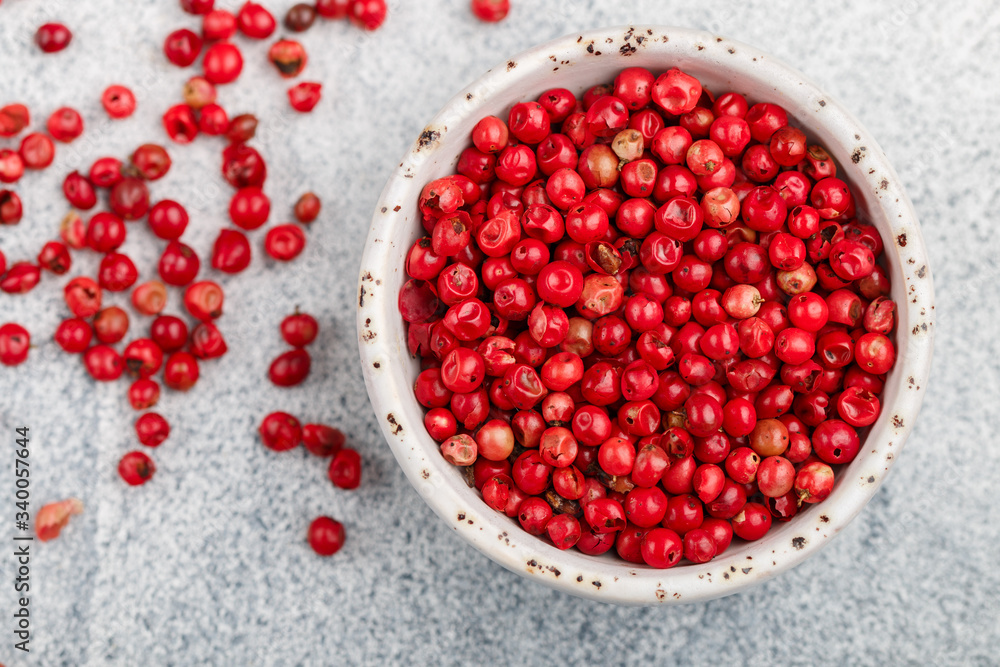 Pink Organic dried Peppercorns in a white bowl on a light concrete or stone background close-up. Spices and seasonings. Selective focus, top view and copy space Pink Organic dried Peppercorns in a white bowl on a light concrete or stone background close-up. Spices and seasonings. Selective focus, top view and copy space