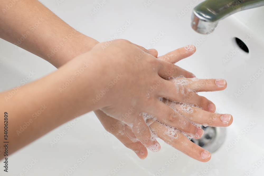 Girl washing hands in a correct way. Small child carefully washes hands with soap Girl washing hands in a correct way. Small child carefully washes hands with soap