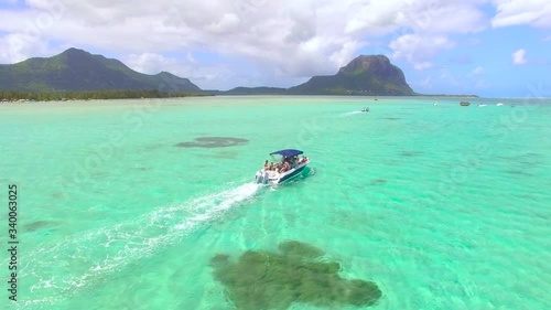 Aerial view of a tour boat in Ile aux benitiers Mauritius. Beautiful exotic island. Reverse flight revealing view of Le Morne mountain. photo