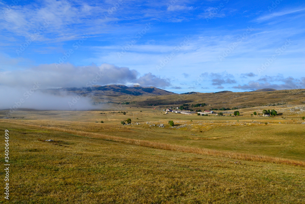 Fototapeta premium Clouds creep on the ground. Panoramic road in National Park Durmitor, Montenegro.