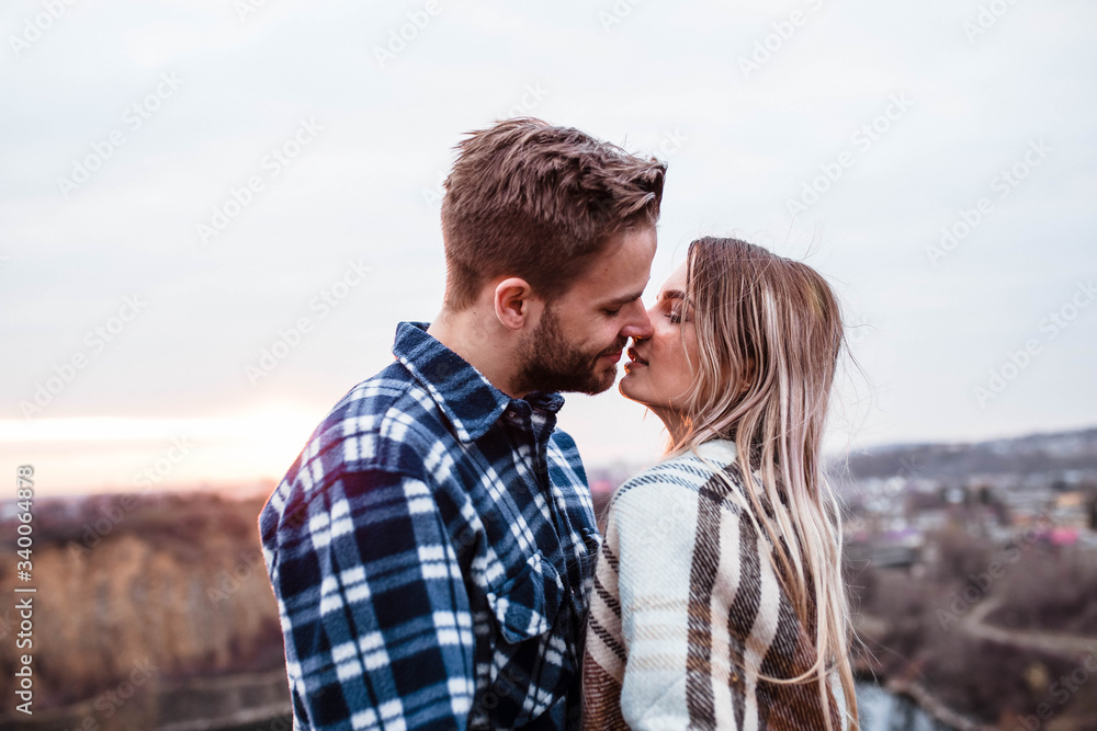 Young couple kissing at sunset. Man and woman. Man in shirt . Camping. Young couple kissing at sunset. Man and woman. Man in shirt . Camping.