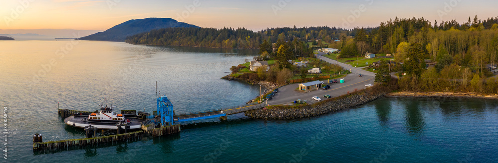 Aerial View of a Ferry Boat Landing at the Island Dock. Aerial shot of a small 21 car ferry landing at the Lummi Island ferry dock on a beautiful sunlit morning in the the Pacific Northwest, USA.