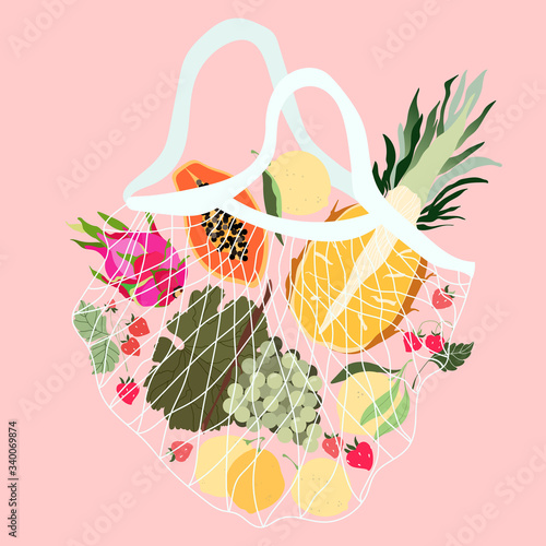 Fruits in a mesh bag. Variety of fresh tropical fruits in a reusable ECO bag. Pineapple, grapes, dragonfruit, lemons, and strawberries from local grocery shops. Healthy food delivery.