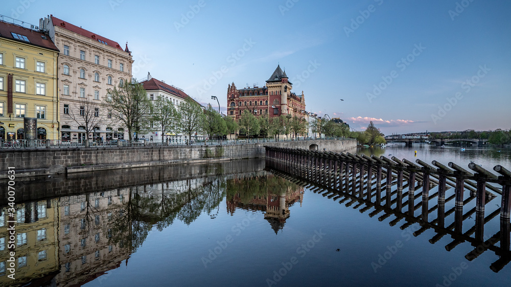 Fototapeta premium Vibrant colorful street in Prague Czech republic with reflection of the builldings in river vltava. Beautiful photo of Prague streets. Tourist destination.