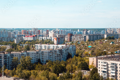 Multi-storey concrete residential buildings and a forest Park against the sky in a big city in the daytime. Architecture and real estate in the metropolis