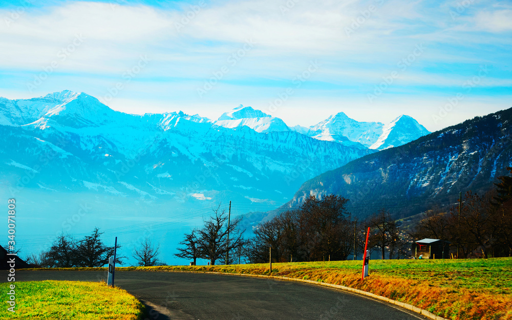 Naklejka premium Road at Sigrilwil village Swiss Alps mountains Thun lake reflex