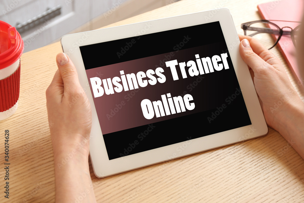 Woman working with tablet at table indoors, closeup. Business trainer online Woman working with tablet at table indoors, closeup. Business trainer online