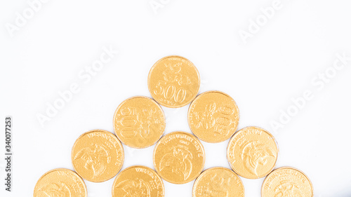 Flat lay of golden coins on white background