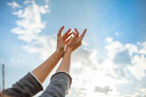 Human hands open palm up on sky background.