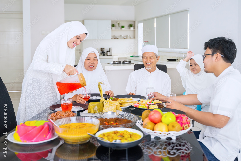Happy muslim family eating together in dining room Happy muslim family eating together in dining room