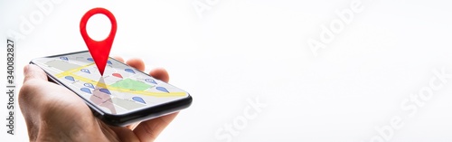 Bild auf Leinwand Human Hand Holding Cellphone With Navigation Sign