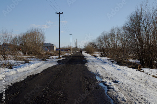 country road in early spring. a man in the distance does a jog. © Dmitry