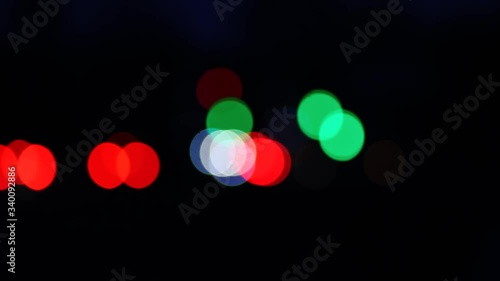 Real camera bokeh, blurry out of focus, of a busy city street with traffic lights and cars passing by. The concept of the lights of the night city.