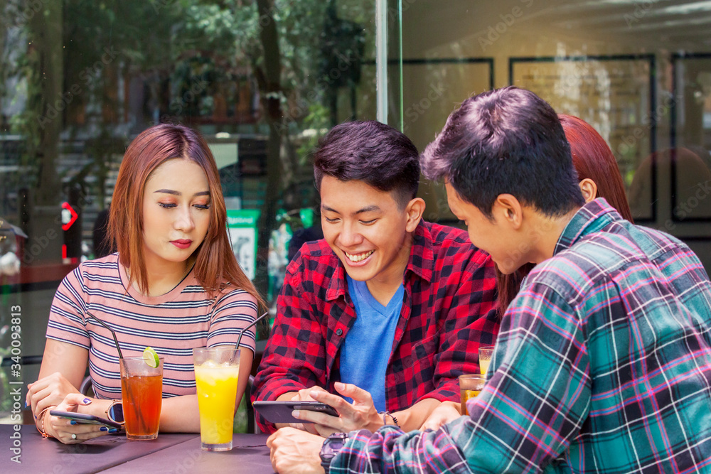 Young man and his friends looking at smartphone Young man and his friends looking at smartphone