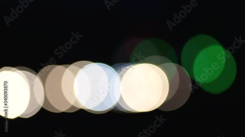 Street of a night city, blurry headlights of traffic cars at night. Defocused, abstract bokeh effect.