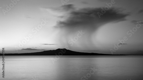 Black and white image of Milford beach with drifting dark rain clouds