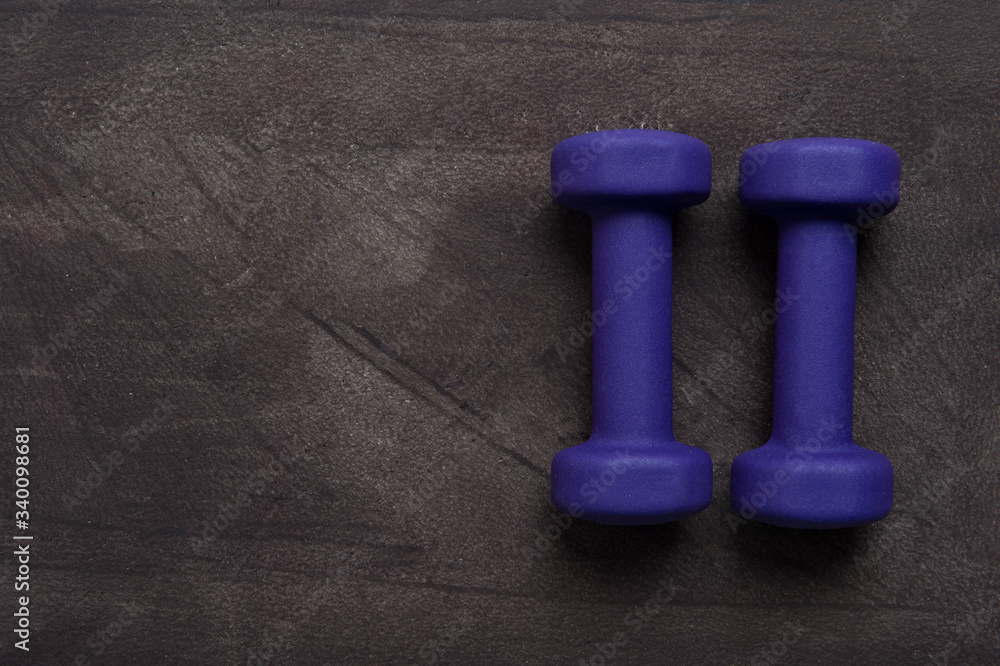 Two dumbbells of blue color isolated on grey background. Healthy lifestyle concept. Two dumbbells of blue color isolated on grey background. Healthy lifestyle concept.