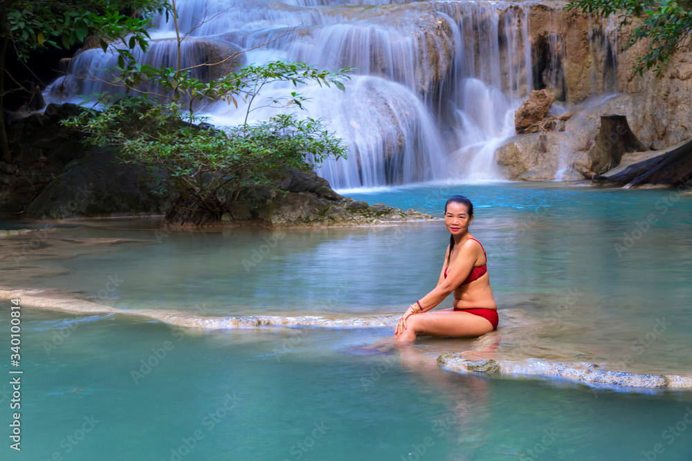 Woman in red bikini beautiful at Erawan Waterfall and natural Woman in red bikini beautiful at Erawan Waterfall and natural