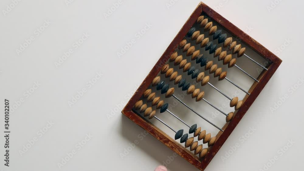 A Elderly Man Moves Wooden Knuckles On A Outdated Vintage Wooden Abacus On A White Desk On The Right Side. A Elderly Man Moves Wooden Knuckles On A Outdated Vintage Wooden Abacus On A White Desk On The Right Side.