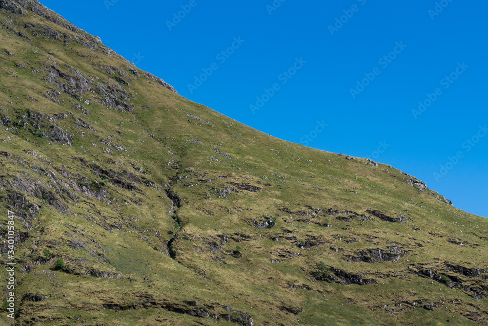 Abstract Angled View of a Rugged Highland Hillside with Cloudless Blue Sky