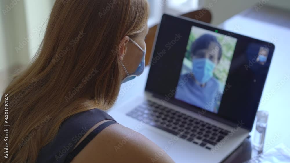 A young woman talks through video conferencing while she is sitting at home during the coronavirus self-isolation period. Social distancing concept A young woman talks through video conferencing while she is sitting at home during the coronavirus self-isolation period. Social distancing concept