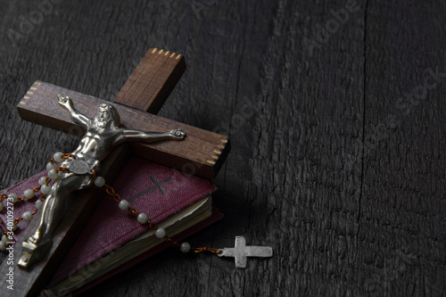 Fotografia Christian cross on wood bible and rosary beads over wooden vintage background
