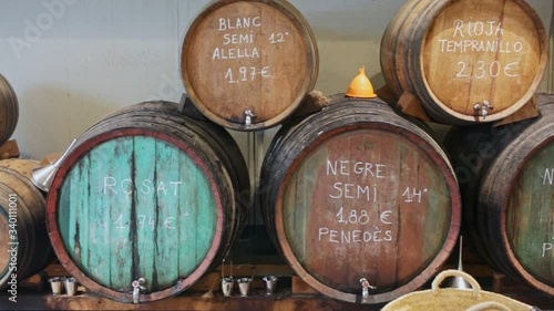 Wooden barrels of traditional Spanish wine on tap in local Catalan store