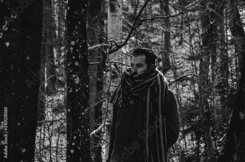 Black and white young man in a forest wearing a scarf