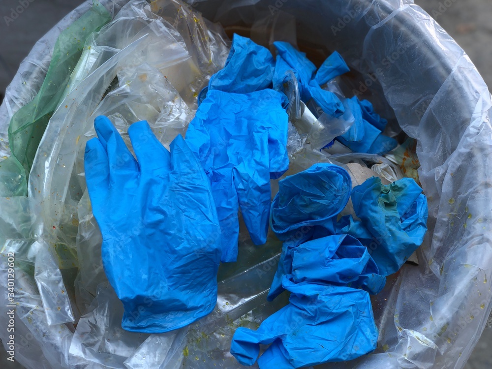 Concept of prevented covid-19. Used infection face mask and dirty medical glove in the trash bin, infectious waste, prevented virus covid-19 by separating infected waste, selective focus. Concept of prevented covid-19. Used infection face mask and dirty medical glove in the trash bin, infectious waste, prevented virus covid-19 by separating infected waste, selective focus.