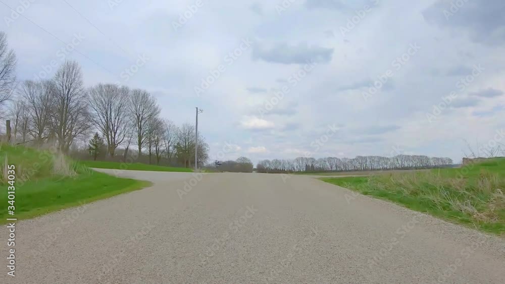 Rear window POV while driving though rural Illinois on gravel road in early spring Rear window POV while driving though rural Illinois on gravel road in early spring